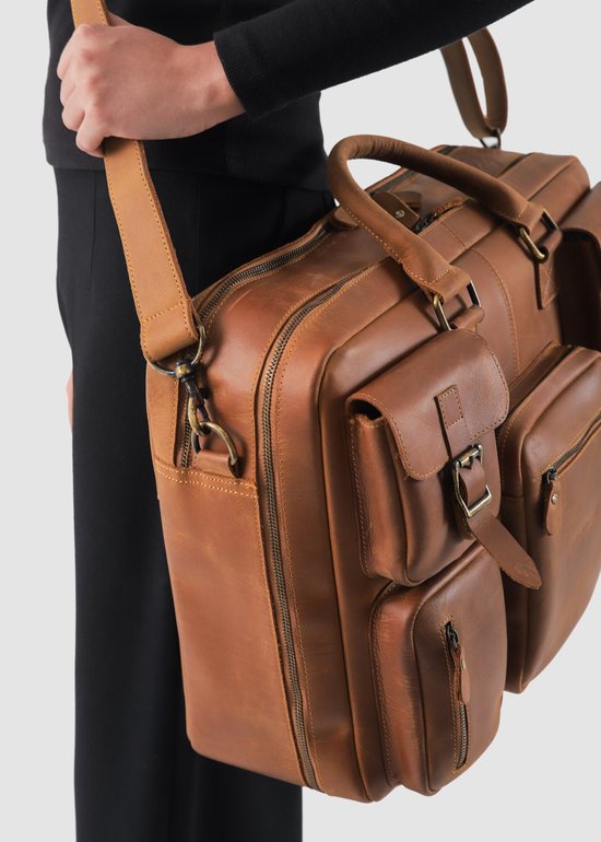 Dichtbij een bruine leren laptoptas met deels gesloten ritsen en gespen.