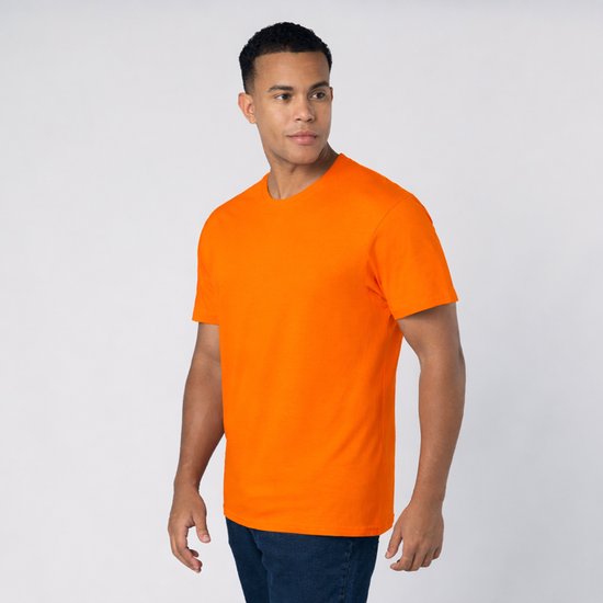 Un homme portant un t-shirt orange vif à manches courtes et col rond, avec un jean.