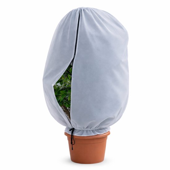 Een plant met groene bladeren in een terracotta pot, bedekt met een lichtgrijze winterhoes met rits. De hoes is licht open geritst, met een zwart trekkoord aan de onderkant.