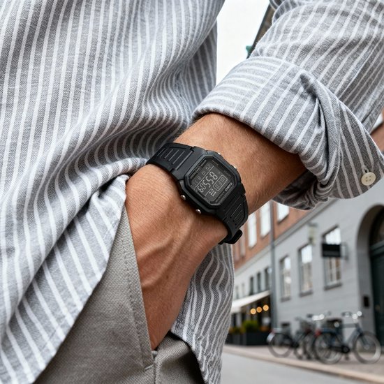 Zwart Casio horloge gedragen door een man met gestreepte blouse.