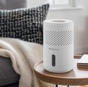 Witte Pro Breeze luchtontvochtiger op een bijzettafel naast een bank.