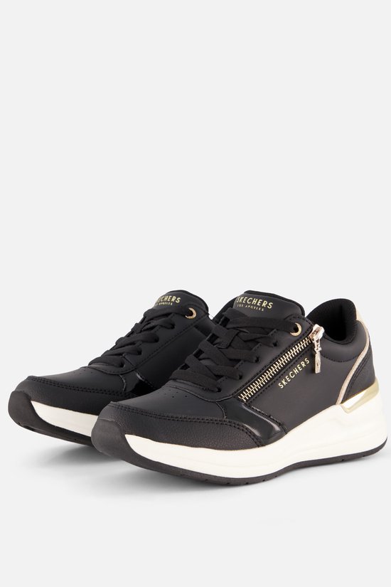 Paar zwarte Skechers sneakers met gouden accenten, ritsen en witte zolen.