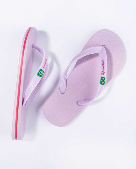 Lichtpaarse Ipanema slippers met rode accenten op de zoolrand en Braziliaanse vlag op de bandjes.