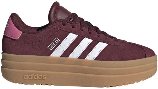 Bordeauxrode Adidas sneakers met witte strepen, een dikke bruine zool en een roze hielstuk.