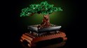 LEGO Bonsaiboompje met groene bladeren in een zwarte pot op een houten standaard.