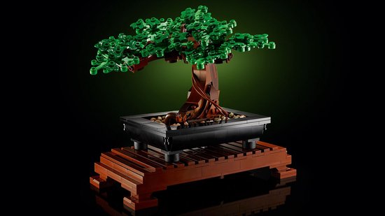 LEGO Bonsaiboompje met groene bladeren in een zwarte pot op een houten standaard.