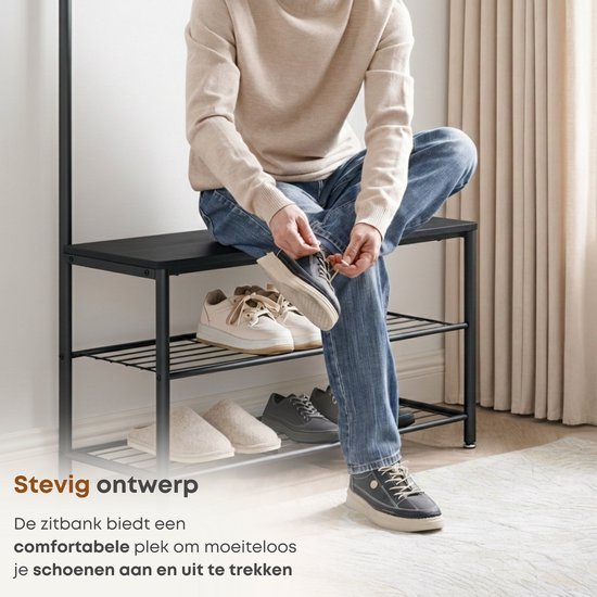 Man met spijkerbroek strikt zijn schoenen op de zwarte zitbank van het garderoberek.