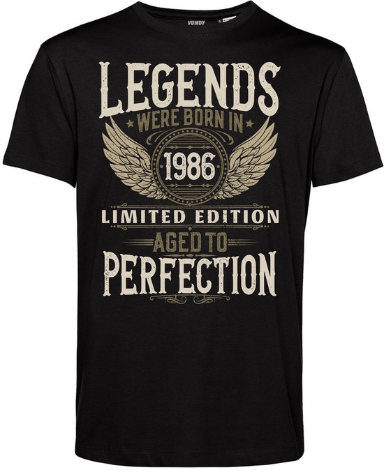 T-shirt noir avec le texte 'LEGENDS WERE BORN IN 1986 LIMITED EDITION AGED TO PERFECTION' en lettres crème, avec des ailes autour de 1986.