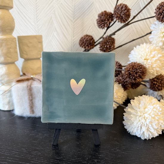 Groen tegeltje met een zilver holografisch hartje, staand op een zwart mini-ezeltje.