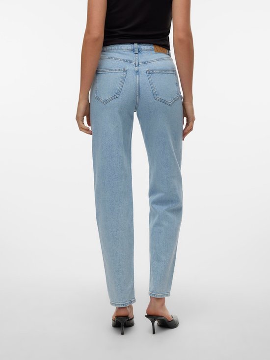 Model van achteren gezien in lichtblauwe jeans met een hoge taille en rechte pijpen. Draagt zwarte hakken.