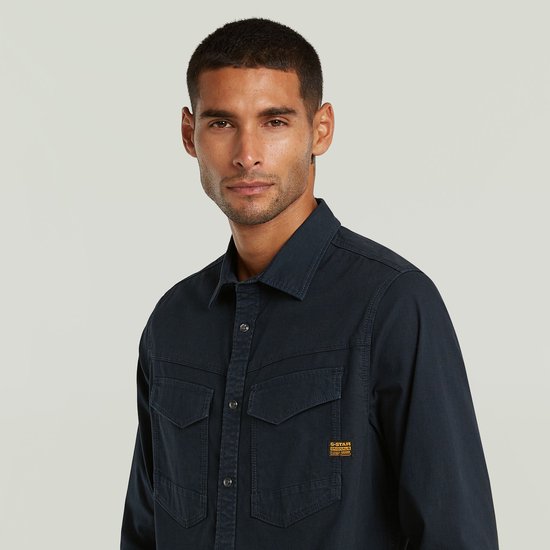 Close-up van een donkerblauw G-Star overhemd met twee borstzakken.