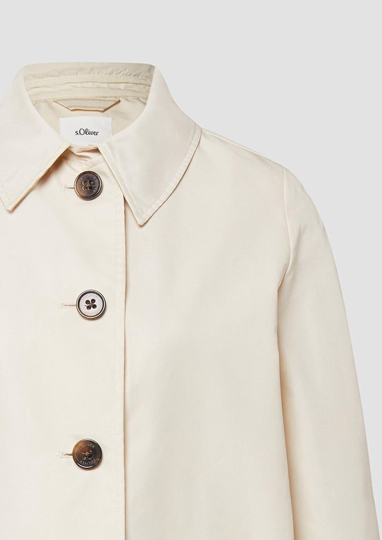 Crèmekleurige trenchcoat, close-up van kraag en knopen met s.Oliver logo.
