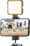 Smartphone met springende vrouwen, verlicht door een MOJOGEAR mini LED lampje.