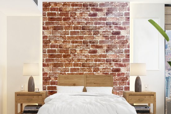 Une vue d'un mur de briques dont la plupart sont marron mais débordant de cm blanc