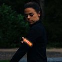 Vrouw met oranje LED armband om haar arm.