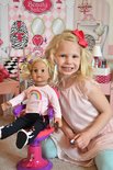Een meisje met blond haar en een rode strik in haar haar speelt met een pop met blond haar in een roze jurkje.