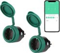 Twee groene en zwarte slimme stekkers naast een smartphone waarop een schema-instelling wordt getoond.