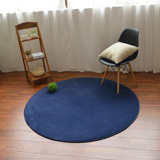 Tapis rond bleu foncé avec une chaise noire, une table d'appoint et des décorations.
