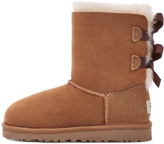 Bruine UGG laars met witte vacht voering en twee bruine strikken op de achterkant, ander zijaanzicht.