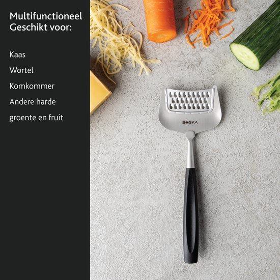 Boska kaasrasp Milano+ met zwart handvat, naast geraspte kaas, wortel, komkommer en een stuk kaas.