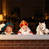 Raamsticker van Piet, Sinterklaas en een wit paard die over een bakstenen muur naar binnen kijken.