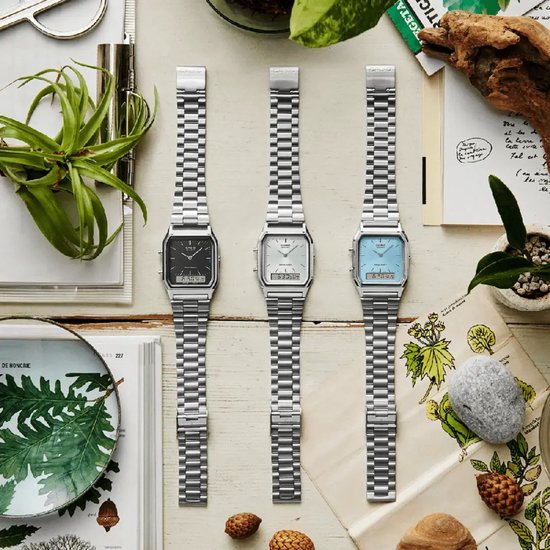 Drie Casio horloges met zilverkleurige stalen banden en vierkante wijzerplaten in zwart, zilver en lichtblauw.