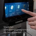 Vinger selecteert ontkalken op het touchscreen van een Siemens machine.