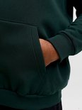 Close-up van de kangoeroezak op een donkergroen JACK & JONES vest met rits.