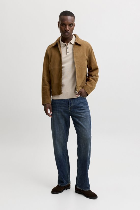Man met beige polo, bruine jas en spijkerbroek.