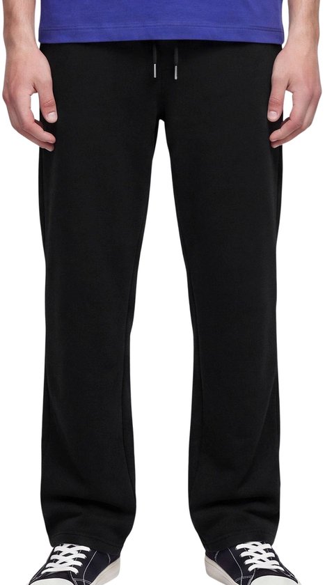 Close-up van een zwarte joggingbroek met trekkoord, gedragen onder een blauw T-shirt.