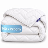Wit, gevouwen dekbed met een zigzagpatroon en een label van 140 x 220 cm.