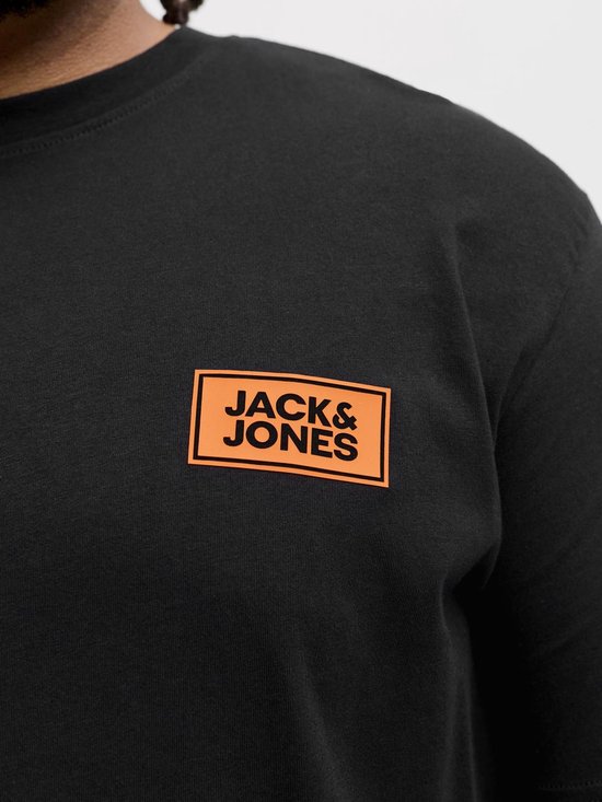 Close-up van een zwart T-shirt met een oranje rechthoekige patch met het 'JACK & JONES' logo op de borst.