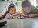 Kinderen spelen met een Lego City camper set buiten.