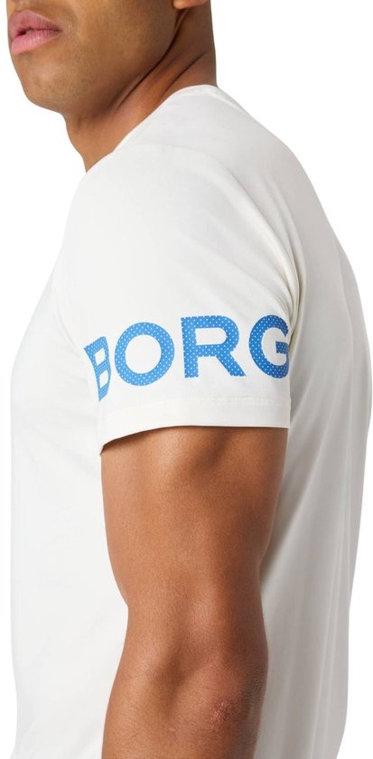 Close-up van witte T-shirt met blauwe BORG opdruk met stippen op de mouw.