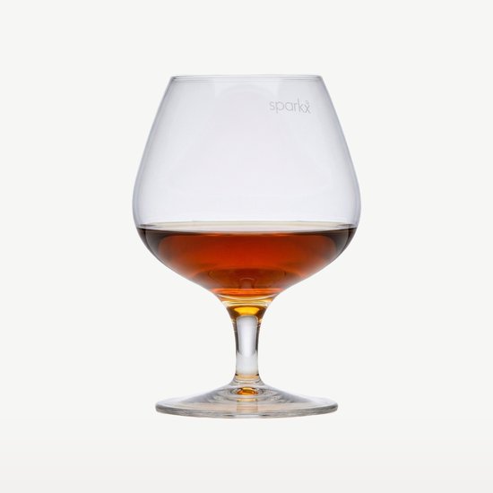 Un verre à cognac rempli de boisson ambrée, avec le texte 'sparkx' gravé sur le calice.