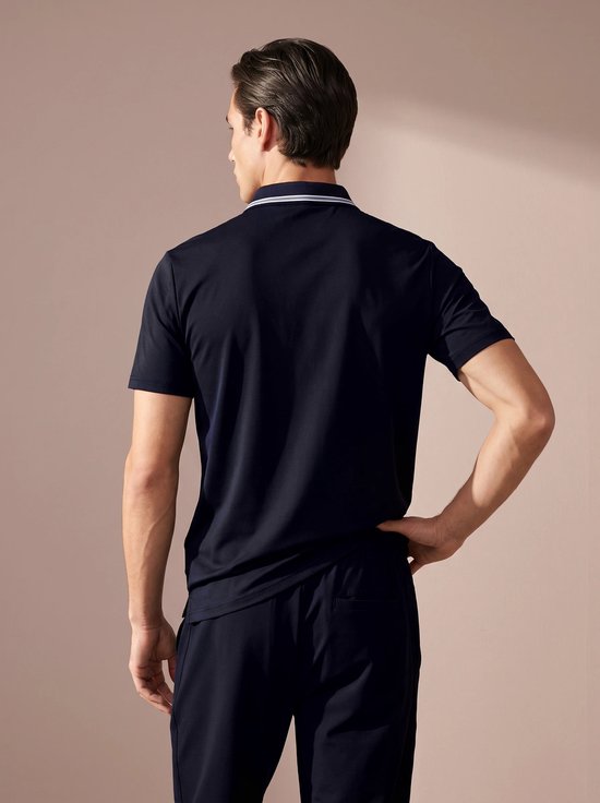 Man draagt de achterkant van een donkerblauw poloshirt met kraag met witte en blauwe strepen.