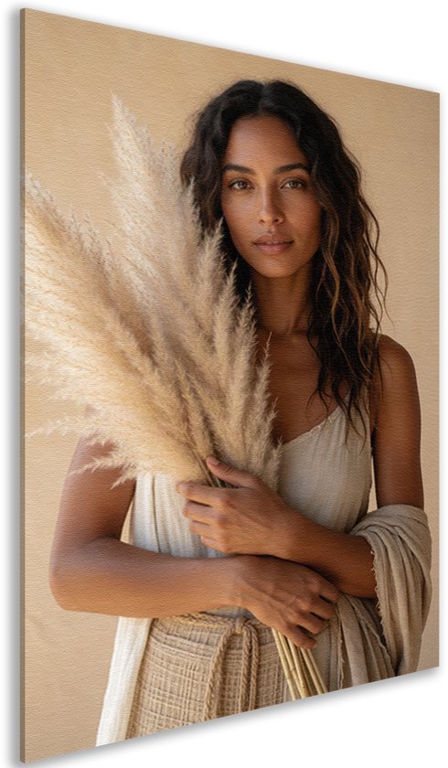 Zijaanzicht van een canvas schilderij met de afbeelding van een vrouw in beige kleding die pampasgras vasthoudt.