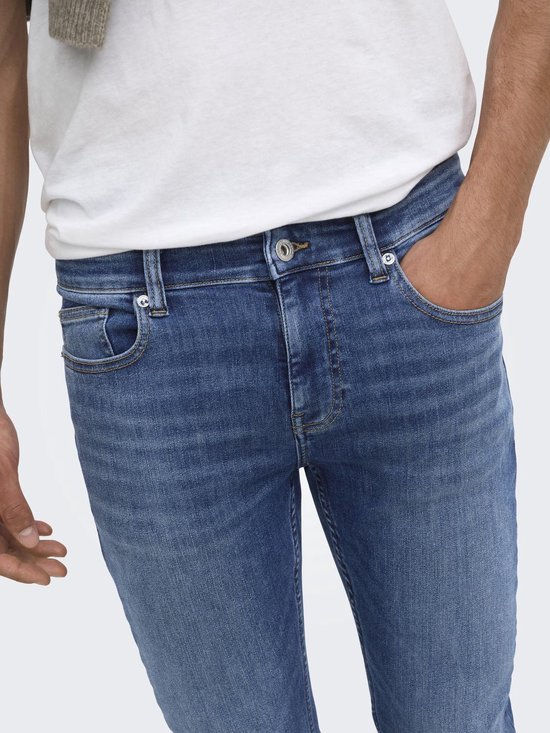 Close-up van de taille en zakken van een blauwe skinny jeans.