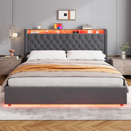 Donkergrijs gestoffeerd bed met capitonnering, houten legplanken en LED-verlichting in het hoofdbord, en gekleurde LED-verlichting onder de rand.