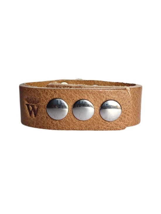 Bruin leren armband versierd met drie grote zilverkleurige studs aan de voorkant.