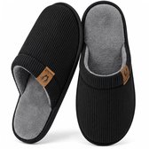 Paar zwarte corduroy pantoffels met een grijze fleecevoering en een klein 'Comfeet' voetlogo-label.