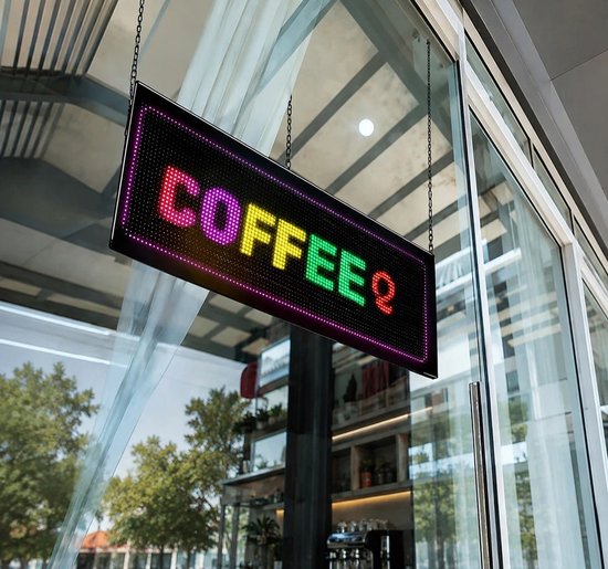 Led-displaypaneel in een winkelraam dat in kleurrijke pixels de tekst COFFEE weergeeft.