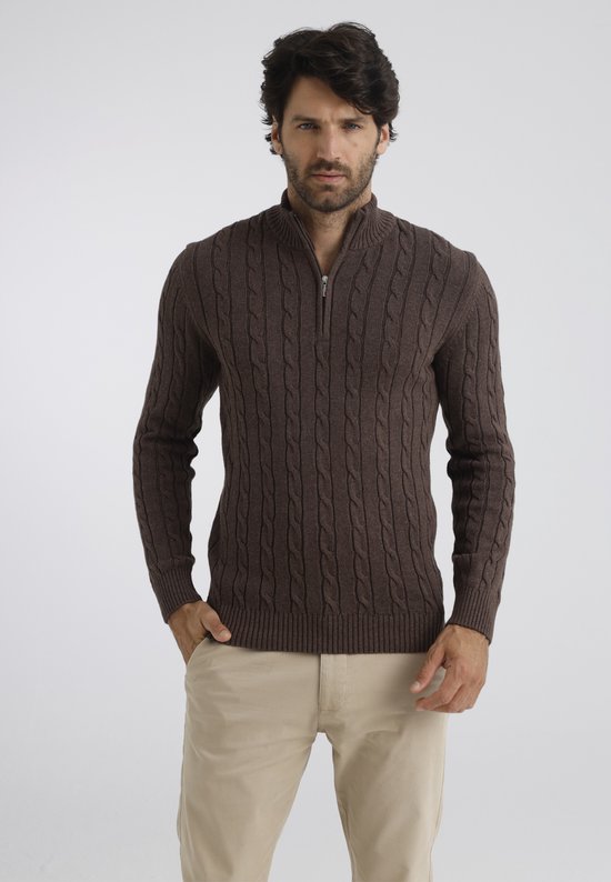 Bruine gebreide kabeltrui met rits tot halverwege de borst, gedragen door een man met beige broek.