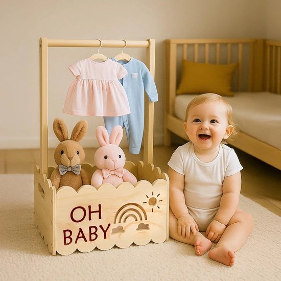 Baby met houten kledingrek, met rompertjes en knuffels. Tekst 'OH BABY' op de voorkant.