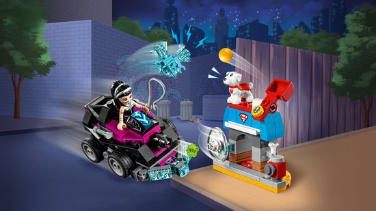 Lego-scène 's nachts, met een vrouw in een roze-zwarte auto die op een hond afrijdt bij een gebouw.