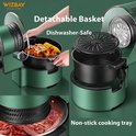 Groene airfryer met een uitneembare mand met kip en maïs, een lege mand en een met vlees gevulde bakplaat.