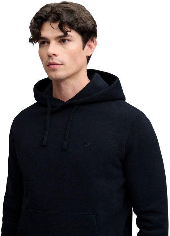 Man met donkerblauwe Superdry hoodie met capuchon, naar links kijkend.