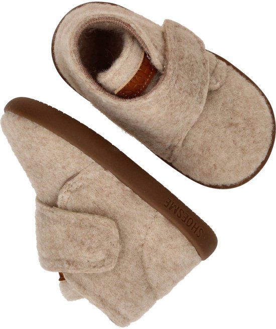 Beige vilten sloffen met bruine zool en klittenbandsluiting.