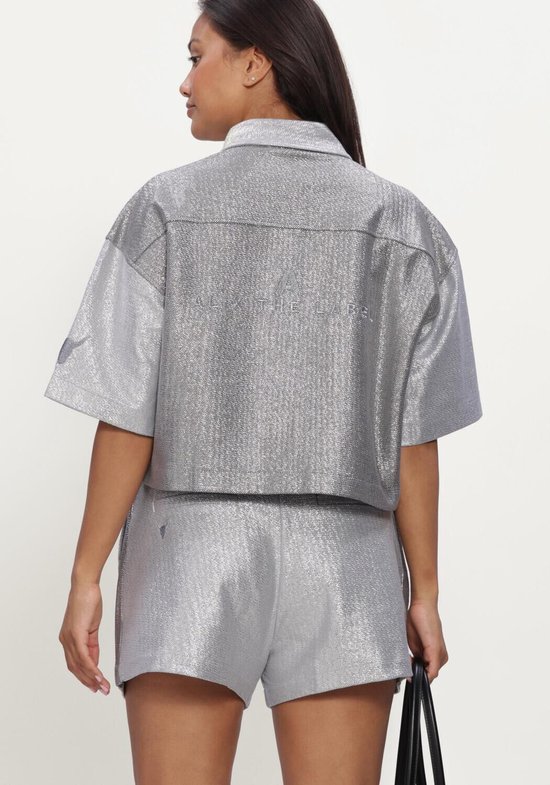 Achterkant van zilverkleurige, glanzende cropped blouse met korte mouwen, met 'ALIX THE LABEL' op de rug.