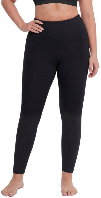 Model draagt een zwarte sportlegging met hoge taille en zakken aan de zijkanten.